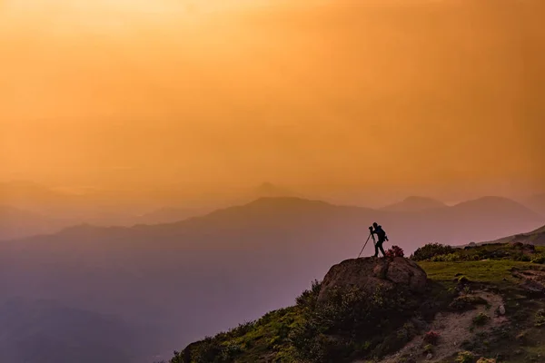 カメラを持った写真家のシルエットが立ち並ぶ山の夕日シーン — ストック写真