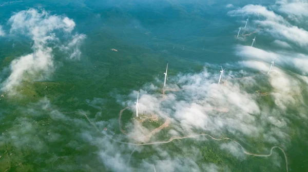 有风车和低云的绿色山地景观 图库图片