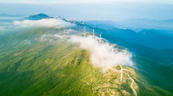 有风车和低云的绿色山地景观 免版税图库照片