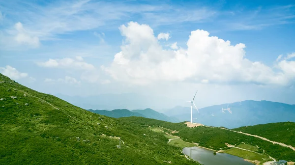 有风车和多云天空的青山景观 图库图片