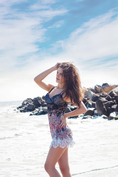 समुद्राच्या पार्श्वभूमीवर एक लहान ड्रेस मध्ये सुंदर युवा श्यामला मुलगी — स्टॉक फोटो, इमेज