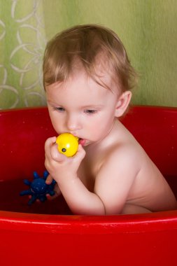 Banyo ve çiğnemek oyuncak oturan güzel sarışın kız