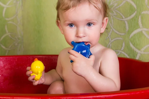 バスルームとかむおもちゃに座って美しい小さなブロンドの女の子 — ストック写真