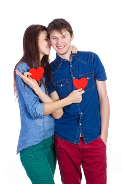 Beautiful young couple holding a small red paper heart in hands — Stock Photo, Image