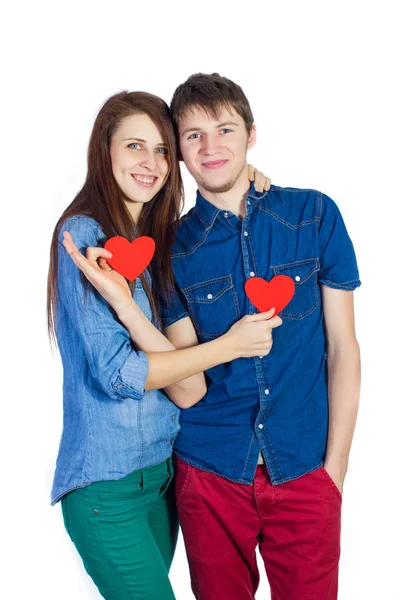 Beautiful young couple holding a small red paper heart in hands — Stock Photo, Image