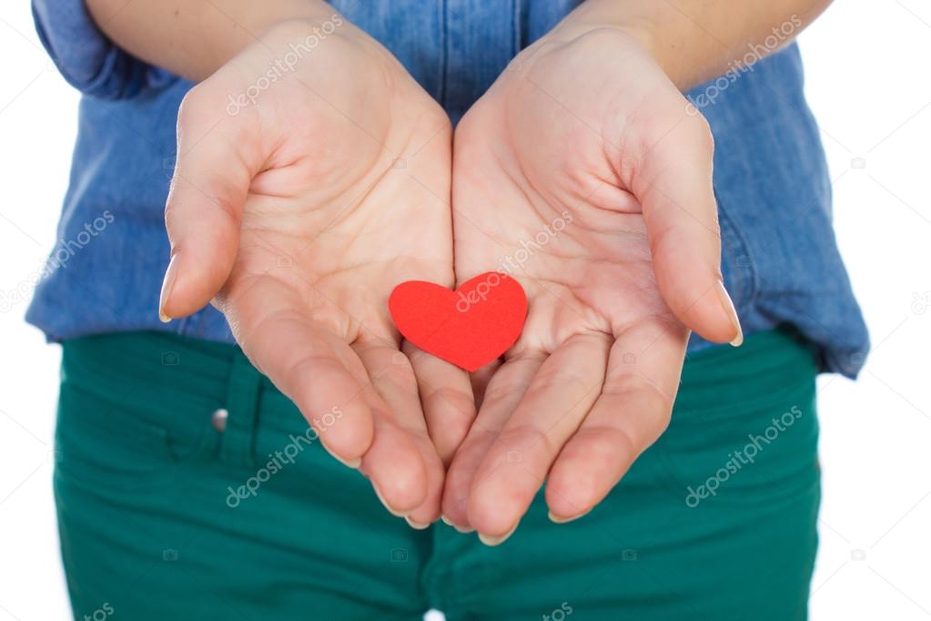 Love and Valentine's Day beautiful brunette holding a red heart in hands isolated on white background