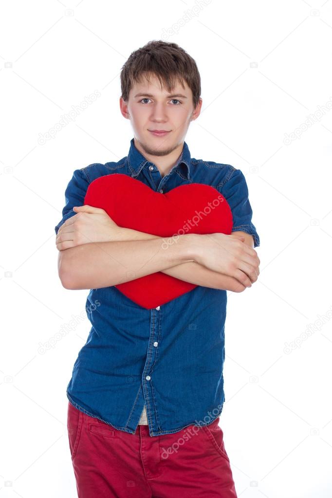 Handsome brunette mans holding a red heart, isolated on white background