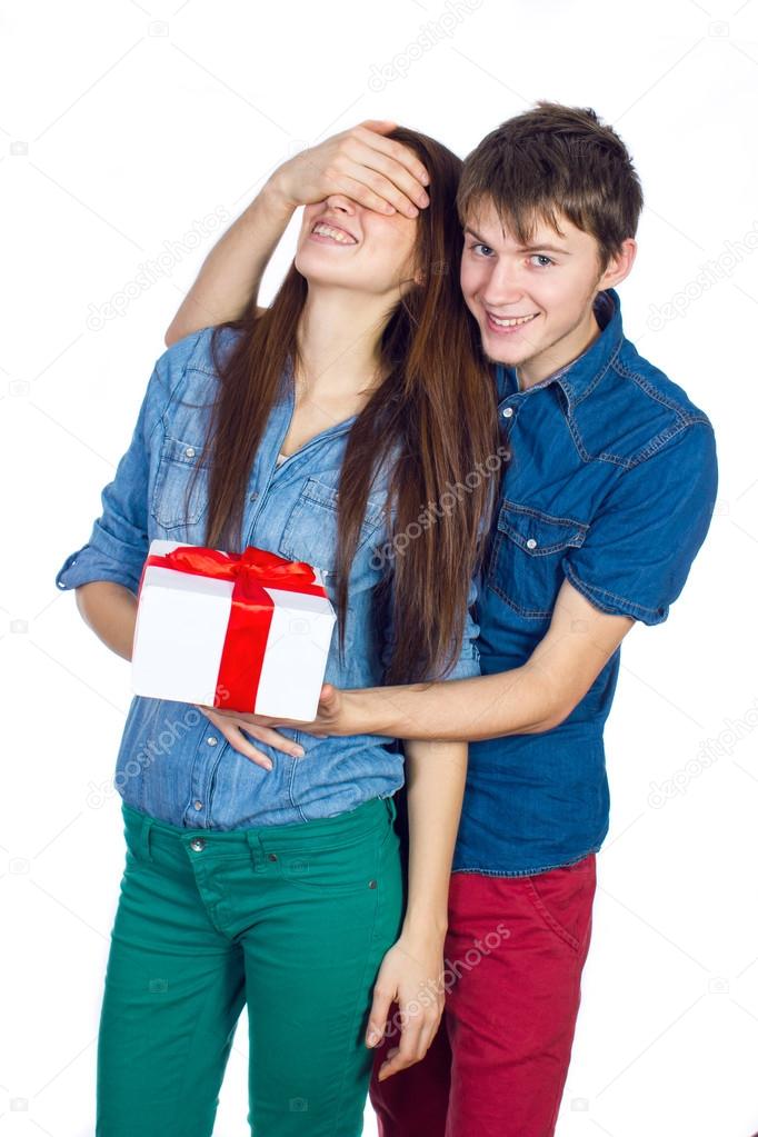 Happy Man giving a gift to his Girlfriend. Happy Young beautiful Couple isolated on a White background.