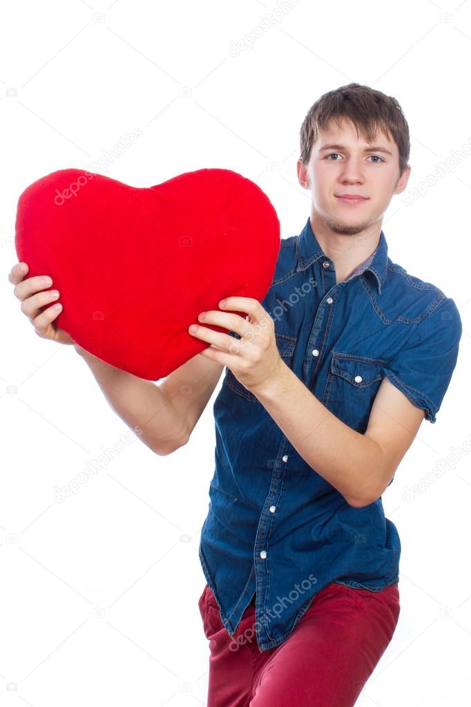Handsome brunette mans holding a red heart, isolated on white background