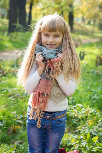 Beautiful little young baby stands in a scarf.  Lovely child smiling — Stock Photo, Image
