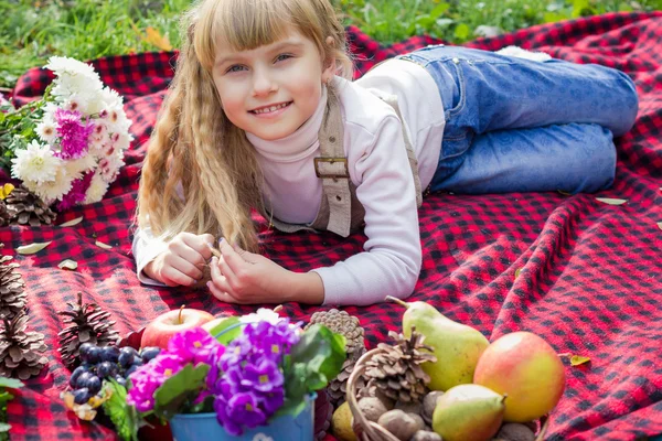 Beautiful little young baby lies on a red plaid. Lovely  child smiling with bright flowers — Stock Photo, Image
