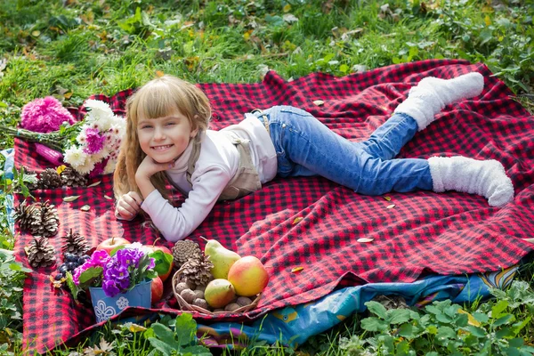 Beautiful little young baby lies on a red plaid. Lovely  child smiling with bright flowers — Stock Photo, Image