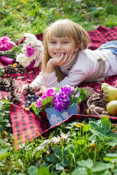 Beautiful little young baby lies on a red plaid. Lovely  child smiling with bright flowers — Stock Photo, Image