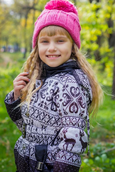 秋の公園で長いブロンドの髪と愛らしい小さなブロンドの女の子。ピンクの帽子の美しい若い赤ちゃん — ストック写真