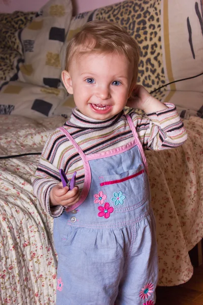 Bébé fille blonde mignonne avec de beaux yeux bleus se tient et souriant — Photo