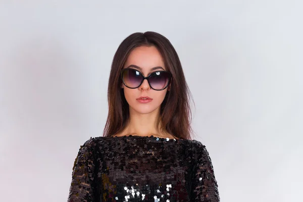 Schöne brünette Mädchen in einem schwarzen Kleid und Sonnenbrille. brünette mit langen schwarzen haaren — Stockfoto