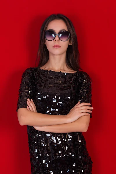 Beautiful brunette girl in a black dress and sunglasses. Brunette with long black hair — Stock Photo, Image