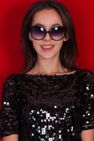 Beautiful brunette girl in a black dress and sunglasses. Brunette with long black hair — Stock Photo, Image