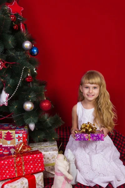 Mooie baby gir in de buurt van de kerstboom in New Year's Eve Rechtenvrije Stockafbeeldingen