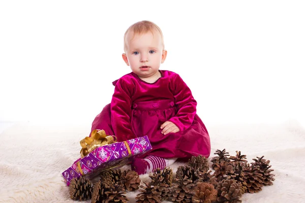 大晦日贈り物を押し笑顔で赤いドレスの女の美しい赤ちゃん — ストック写真