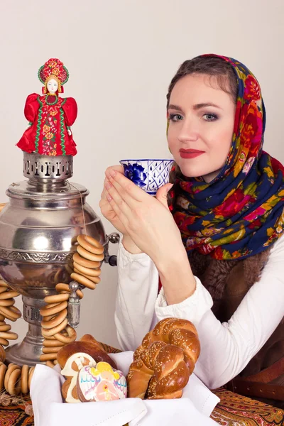 Glimlachend dromen landelijke vrouw met bagels en kopje tee in omslagdoek in New Year's Eve. Rechtenvrije Stockfoto's