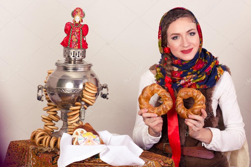 Smiling dreaming rural woman with bagels in shawl in New Year's Eve.