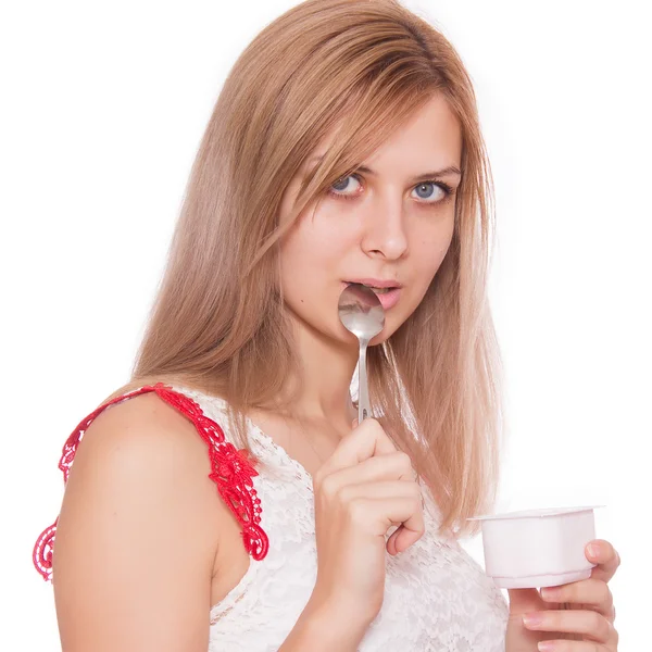 Portret van een lachende jonge vrouw die eten yoghurt geïsoleerd — Stockfoto