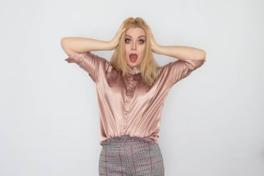 Beyaz arka planda pembe bluzlu, gülümseyen sarışın iş kadını.