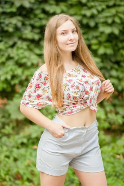Yaz aylarında poz doğa güzel sarışın kız üzerinde uzun kahverengi saçlı güzel bir genç kadının portresi