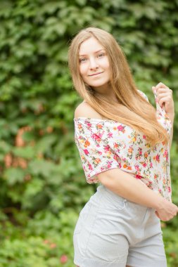 Yaz aylarında poz doğa güzel sarışın kız üzerinde uzun kahverengi saçlı güzel bir genç kadının portresi