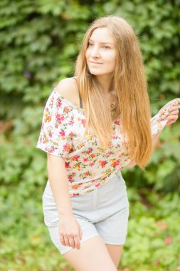 Yaz aylarında poz doğa güzel sarışın kız üzerinde uzun kahverengi saçlı güzel bir genç kadının portresi