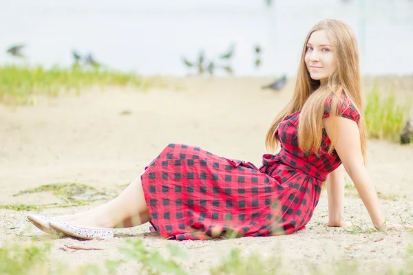 Porträtt av en vacker ung kvinna med långa bruna hår i naturen flicka är avkopplande på stranden nära dammen — Stockfoto