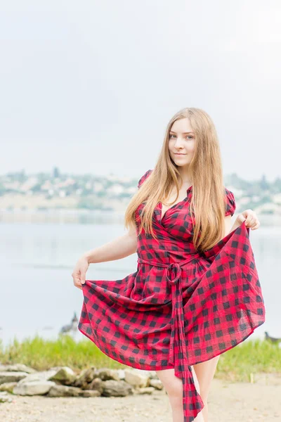 Porträtt av en vacker ung kvinna med långa bruna hår i naturen flicka är avkopplande på stranden nära dammen — Stockfoto