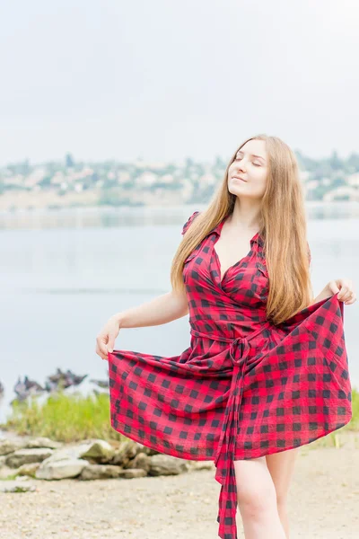 Retrato de una hermosa mujer joven con el pelo largo y castaño en la naturaleza Chica es relajarse en la playa cerca del estanque —  Fotos de Stock