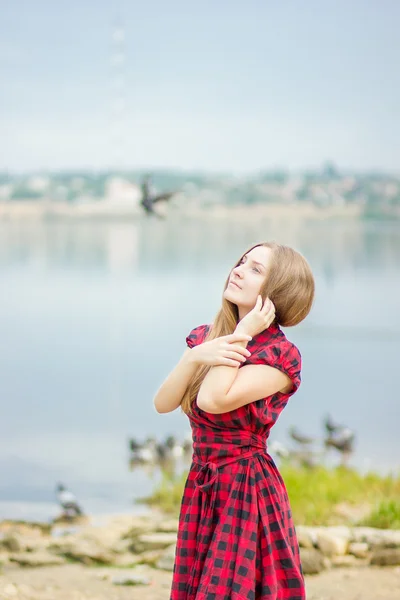 Portrait of a beautiful young woman with long brown hair in nature  Girl is relaxing on the beach near the pond — Stock Photo, Image