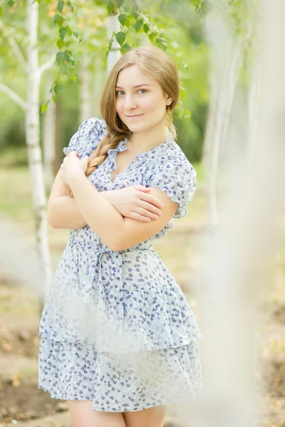 Portrait of a beautiful young woman with brown long hair on nature in a dress with a floral pattern. Girl resting in a birch forest — Stock Photo, Image