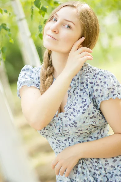 Portrait d'une belle jeune femme aux cheveux longs bruns sur la nature dans une robe à motif floral. Fille reposant dans une forêt de bouleaux — Photo