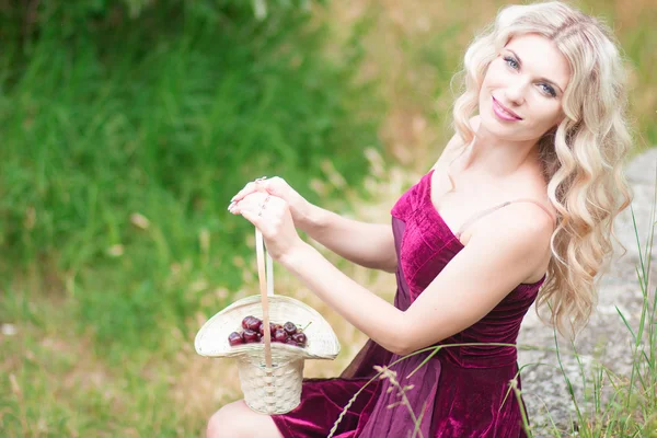 Woman with berries in basket — Stock Photo, Image