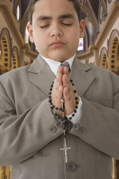 Hispanic boy praying in church