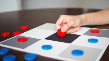 Tahta tablonun üst seçili odak noktasında tic tac toe oyunu oynayan insanlar