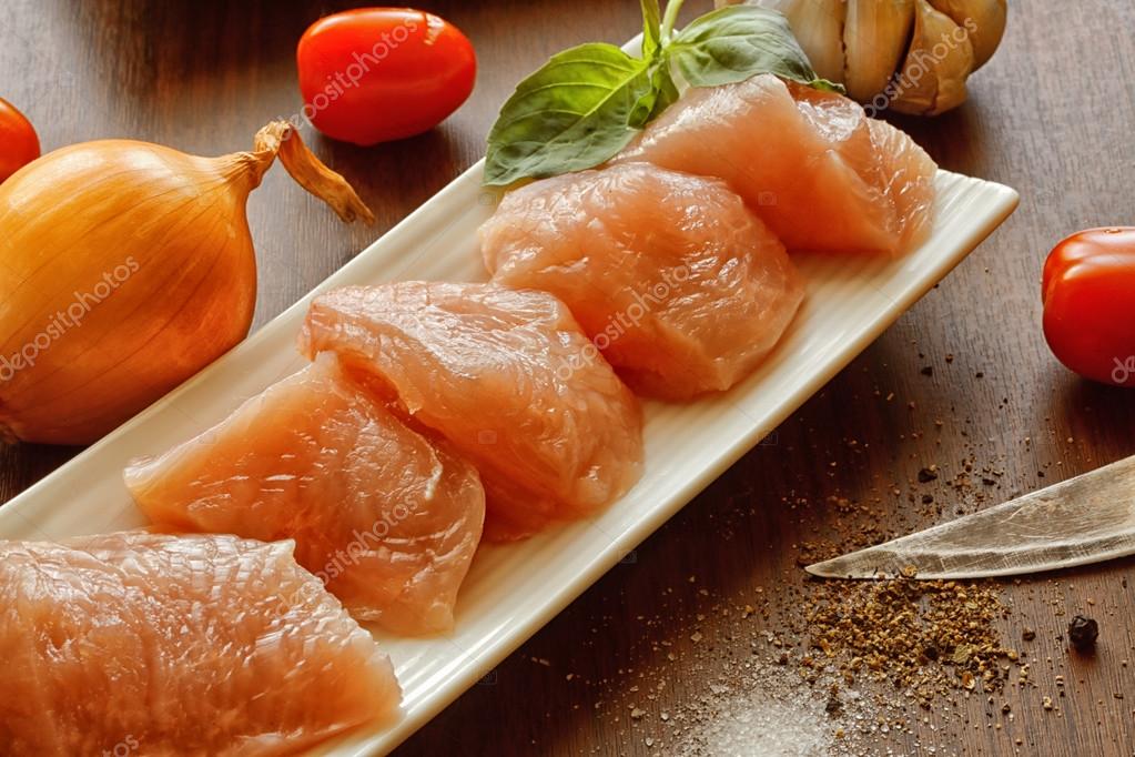 Sliced turkey meat and vegetables on the tables Stock Photo by