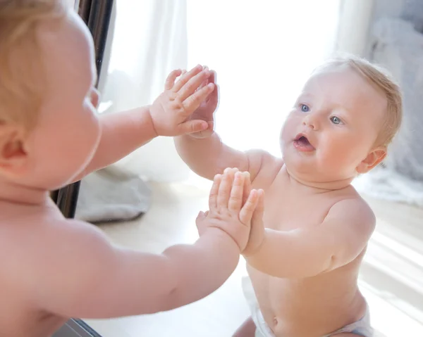 Adorable bebé jugando cerca del espejo —  Fotos de Stock