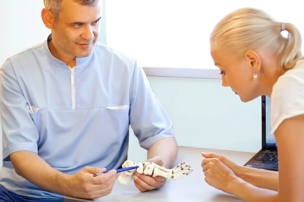 Doktor ortopedist ayaklarını muayene ediyor.