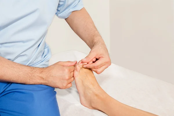 Doctor orthopedist examining feet — Stock Photo, Image