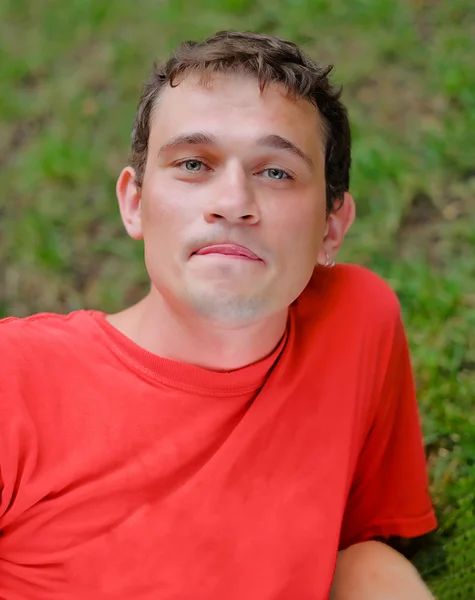 Cher jeune homme relaxant dans un parc — Photo