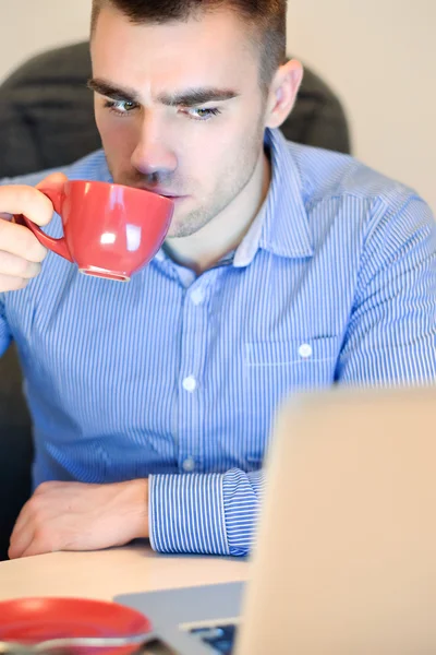 Businessman working on his laptop having coffee — Stock Photo, Image