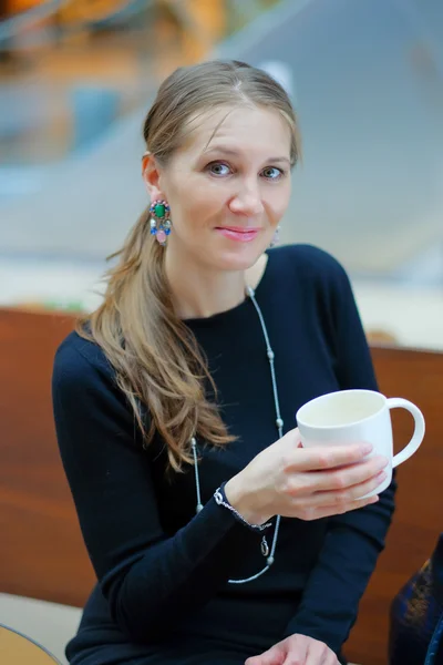 Vacker ung kvinna som dricker kaffe eller te — Stockfoto