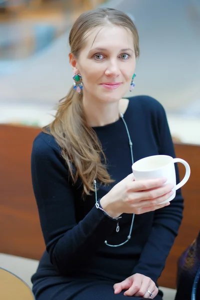 Vacker ung kvinna som dricker kaffe eller te — Stockfoto
