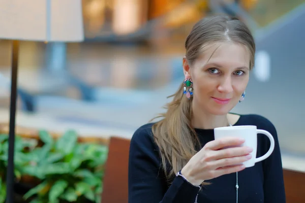 Vacker ung kvinna som dricker kaffe eller te — Stockfoto