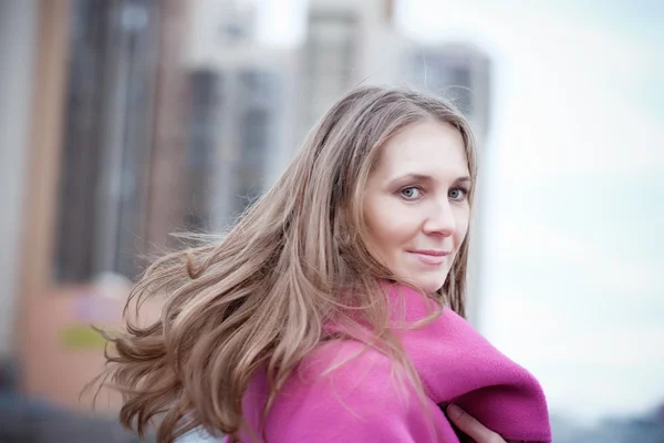 屋外のピンクのコートを着ている金髪の女性 — ストック写真